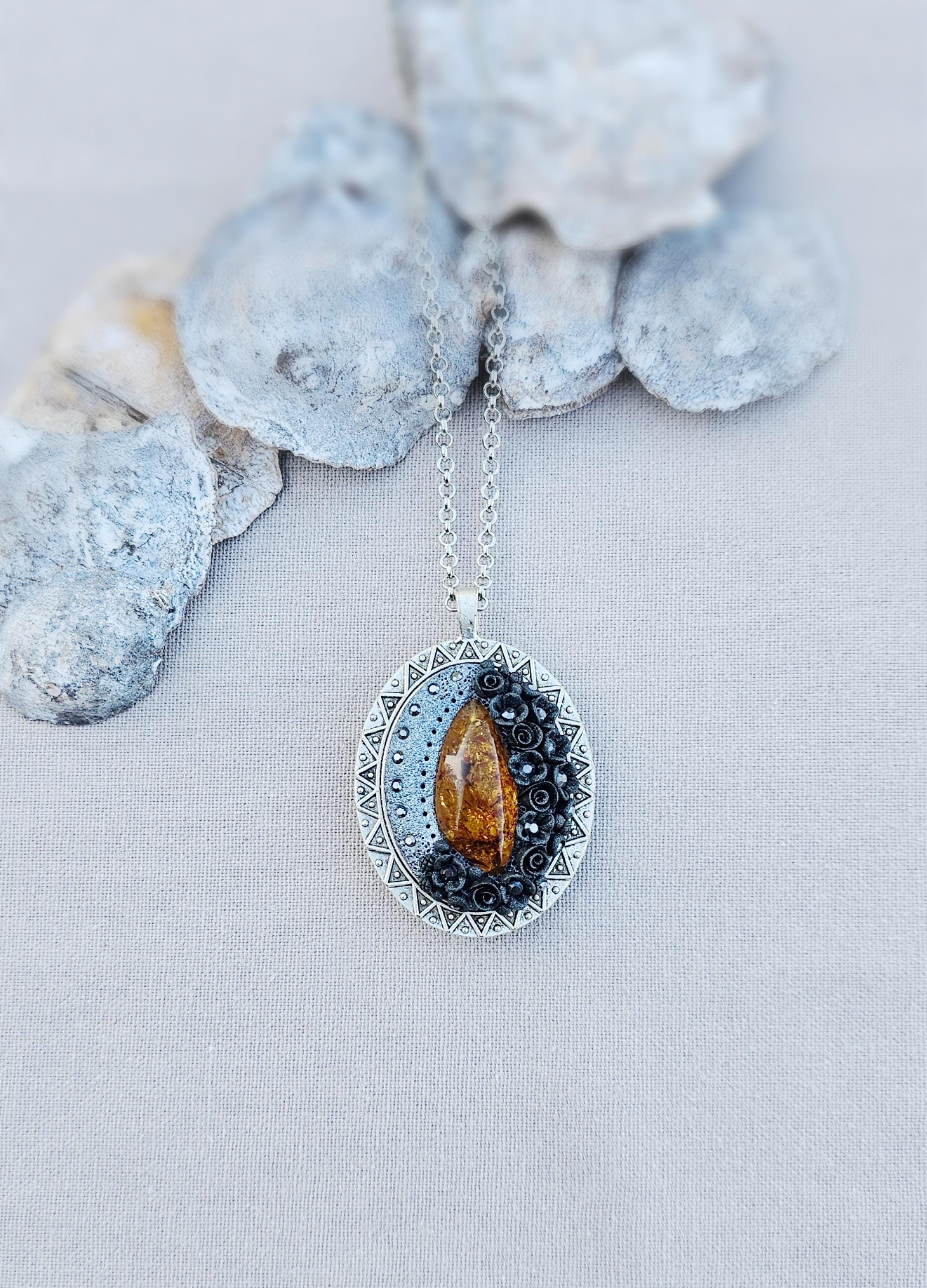 Pendant locket with amber, handmade flowers from polymer clay. On the other side, there is a locket with a heart that opens, inside which you can put a photo or a scent. A great gift for a loved one, or for yourself as a protective amulet.