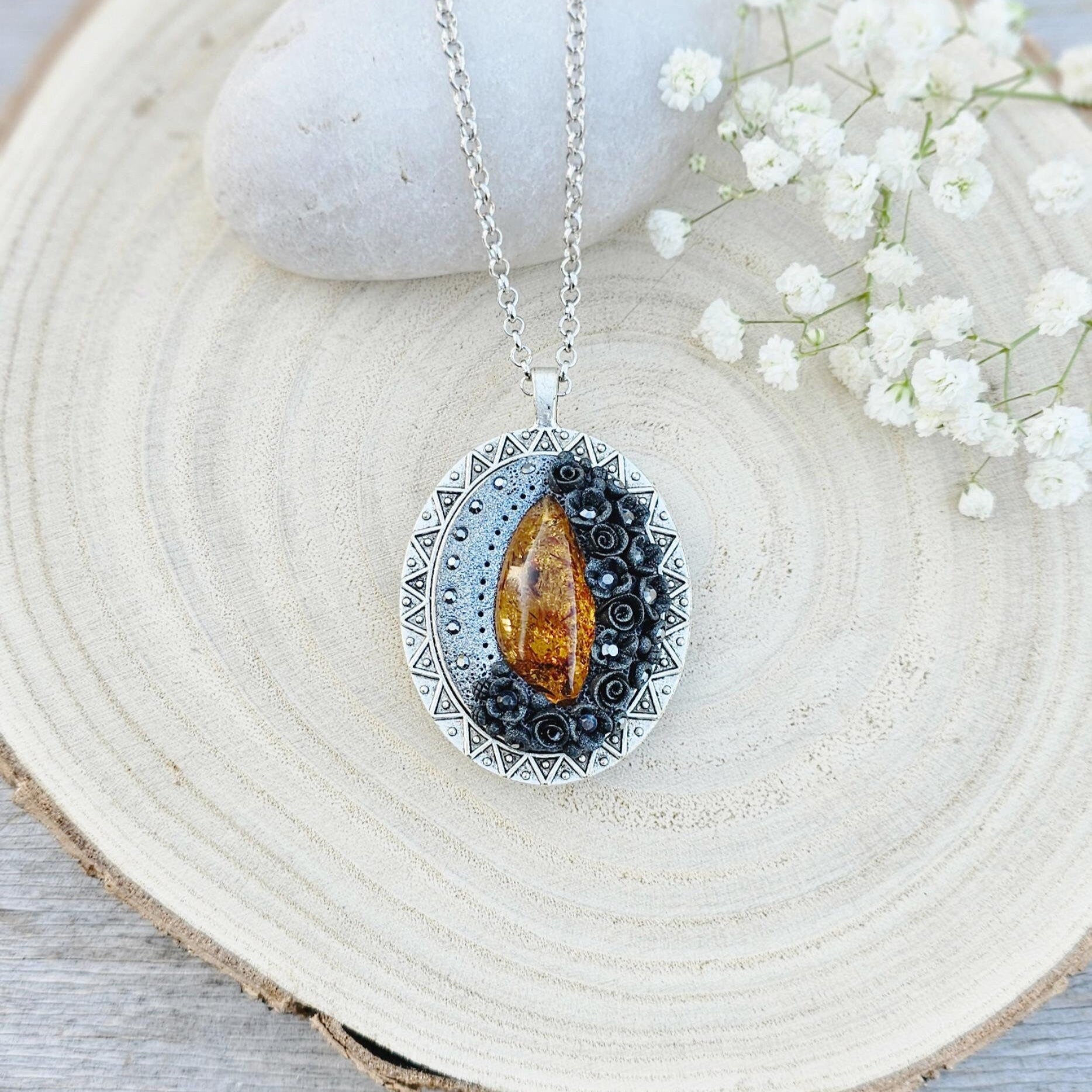 Pendant locket with amber, handmade flowers from polymer clay. On the other side, there is a locket with a heart that opens, inside which you can put a photo or a scent. A great gift for a loved one, or for yourself as a protective amulet.