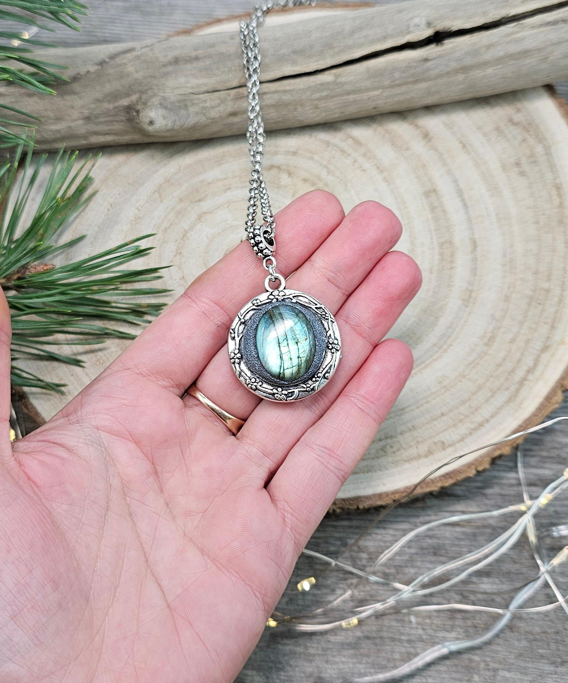 The shimmering labradorite stone, known for its protective and mystical properties, is beautifully framed in polymer clay and set in a silver-tone locket design.