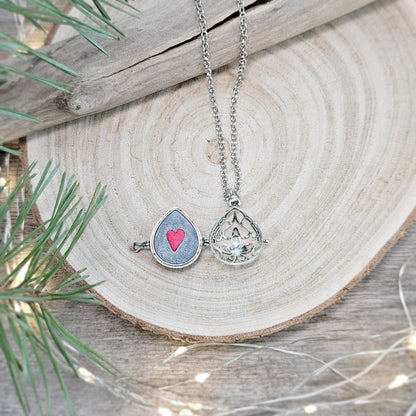 This exquisite handcrafted locket pendant features a mesmerizing Labradorite stone set in a silver-toned metal frame with polymer clay accents.