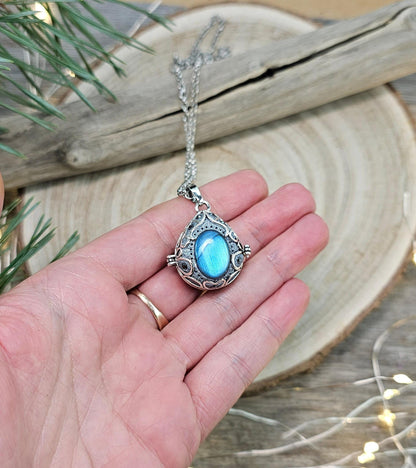This exquisite handcrafted locket pendant features a mesmerizing Labradorite stone set in a silver-toned metal frame with polymer clay accents.