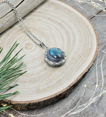 The shimmering labradorite stone, known for its protective and mystical properties, is beautifully framed in polymer clay and set in a silver-tone locket design.