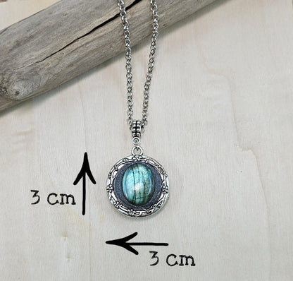 The shimmering labradorite stone, known for its protective and mystical properties, is beautifully framed in polymer clay and set in a silver-tone locket design.