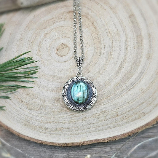The shimmering labradorite stone, known for its protective and mystical properties, is beautifully framed in polymer clay and set in a silver-tone locket design.