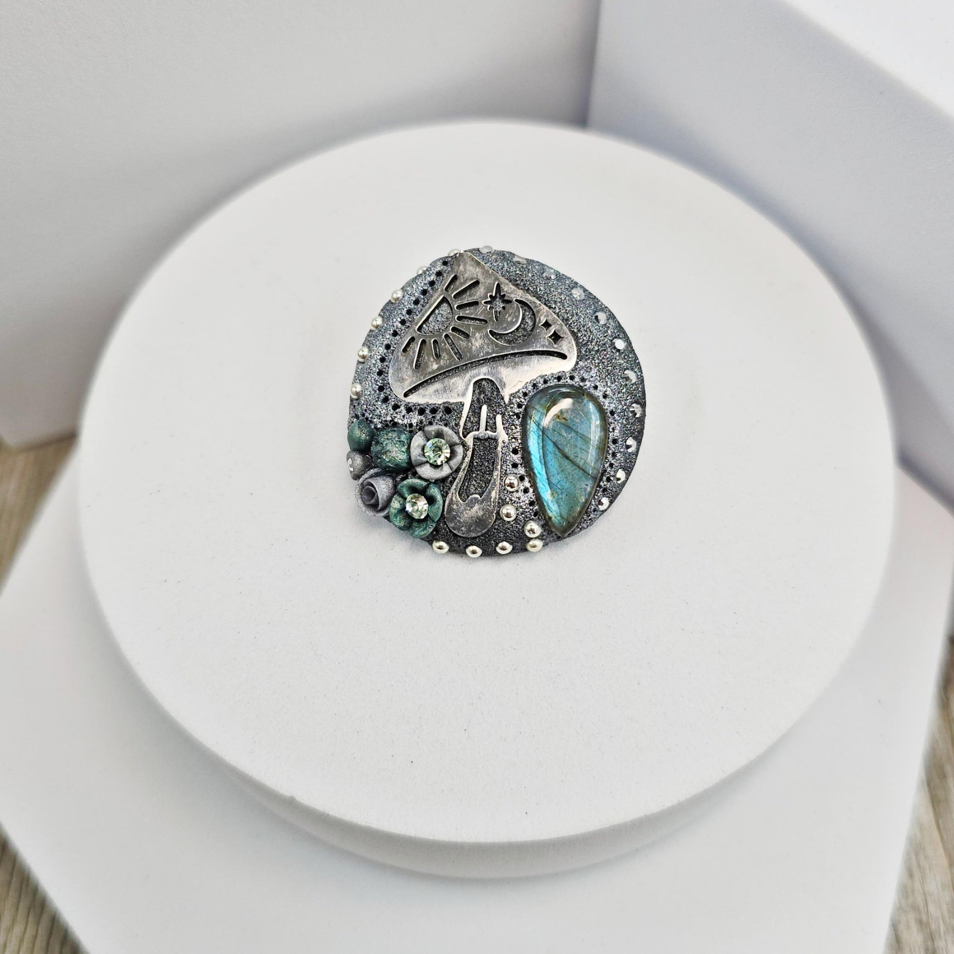 Handmade polymer clay brooch featuring a magical mushroom and a glowing labradorite stone, with stainless steel pin – forest-inspired mystical jewelry.
