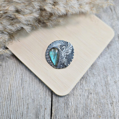 Handmade phoenix brooch with natural labradorite – crafted from polymer clay and stainless steel. Unique mystical jewelry symbolizing rebirth and transformation.