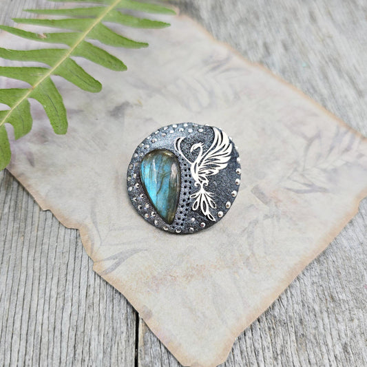 Handmade phoenix brooch with natural labradorite – crafted from polymer clay and stainless steel. Unique mystical jewelry symbolizing rebirth and transformation.